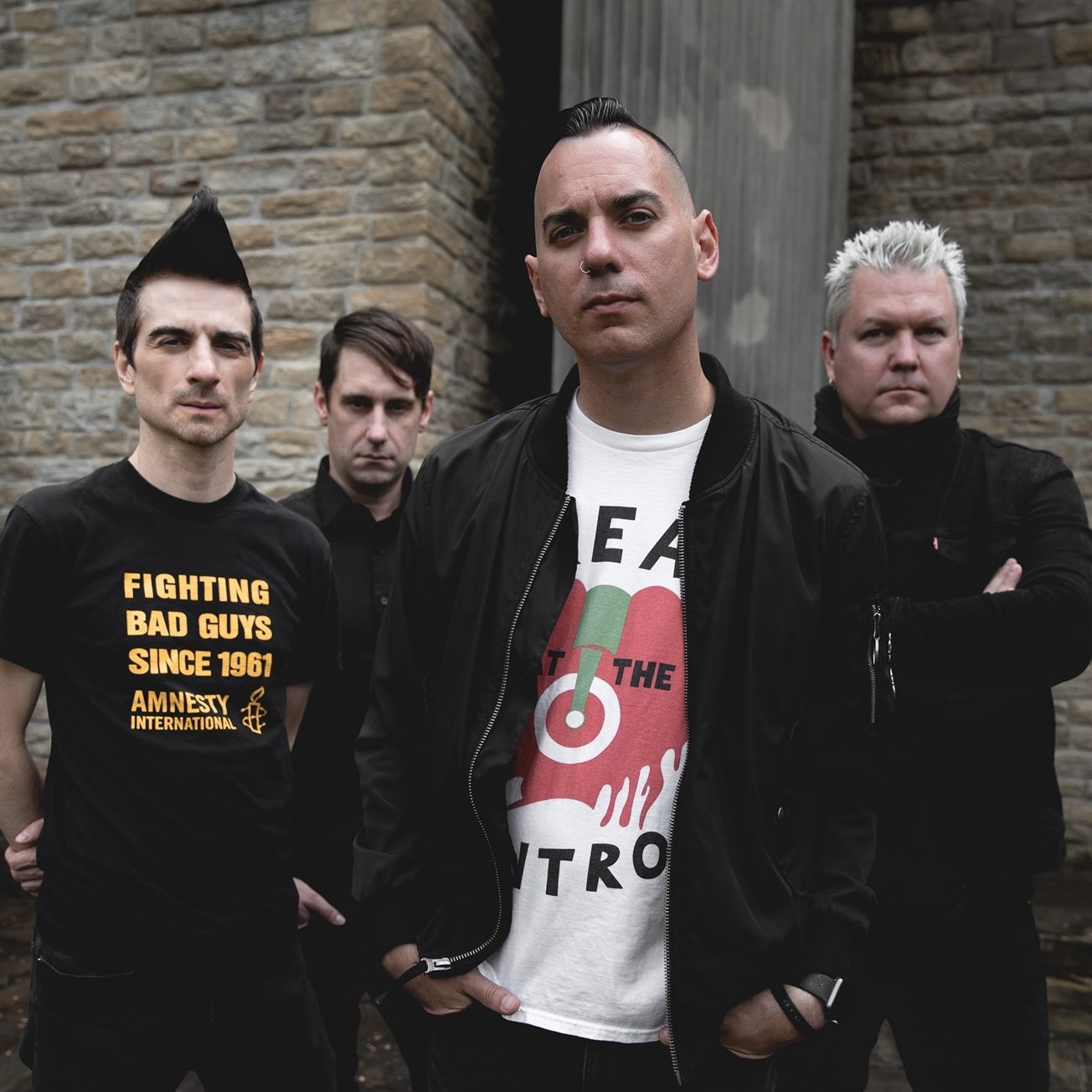 A promotional picture of the band Anti Flag. They are posed against a building.