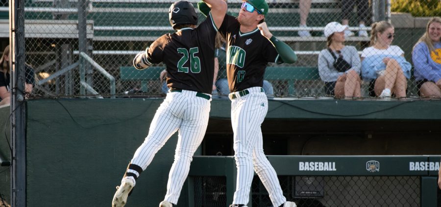 Dillon Masters (13) jumps to bump arms with Will Sturek (26) after Sturek’s two run home run against Marshall University at Bob Wren Stadium in Athens, Ohio, on Tuesday, April 11, 2023.