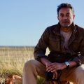 Global conservation scientist M. Sanjayan, host of CHANGING PLANET II, in the outback of Australia, sitting on a rock