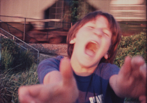 Sam Harkness, age 11, screams as a freight train passes by, Color Super-8mm, 1998.