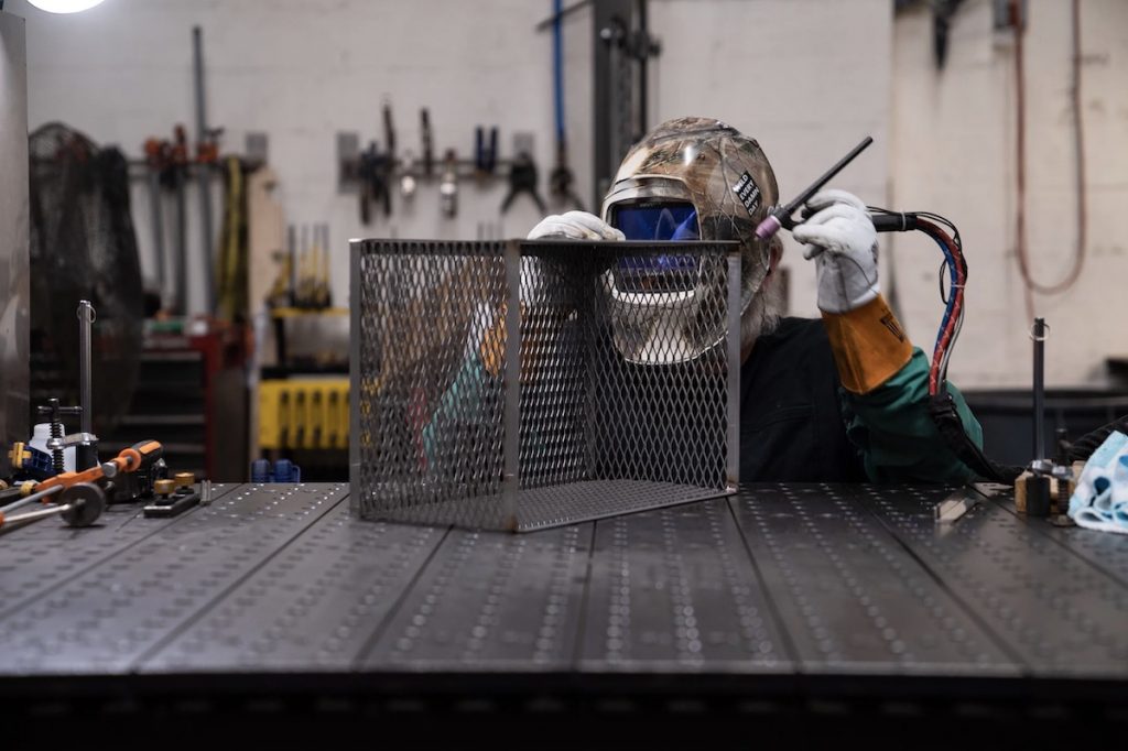 A welder works on a basket at Marlin Steel's Baltimore factory on March 22, 2023.