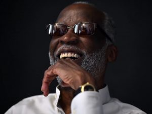 Ahmad Jamal, pictured in 2016. He has glasses on and is against a black background.