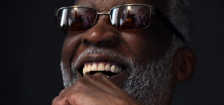 Ahmad Jamal, pictured in 2016. He has glasses on and is against a black background.