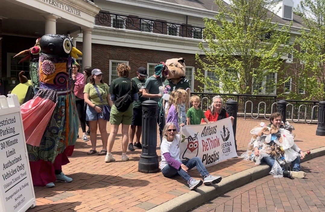 An image taken during Ohio University's Earth Day March on April 21, 2023. The picture depicts a group of people gathered outside of Ohio University's Baker Center holding signs about environmental issues. 