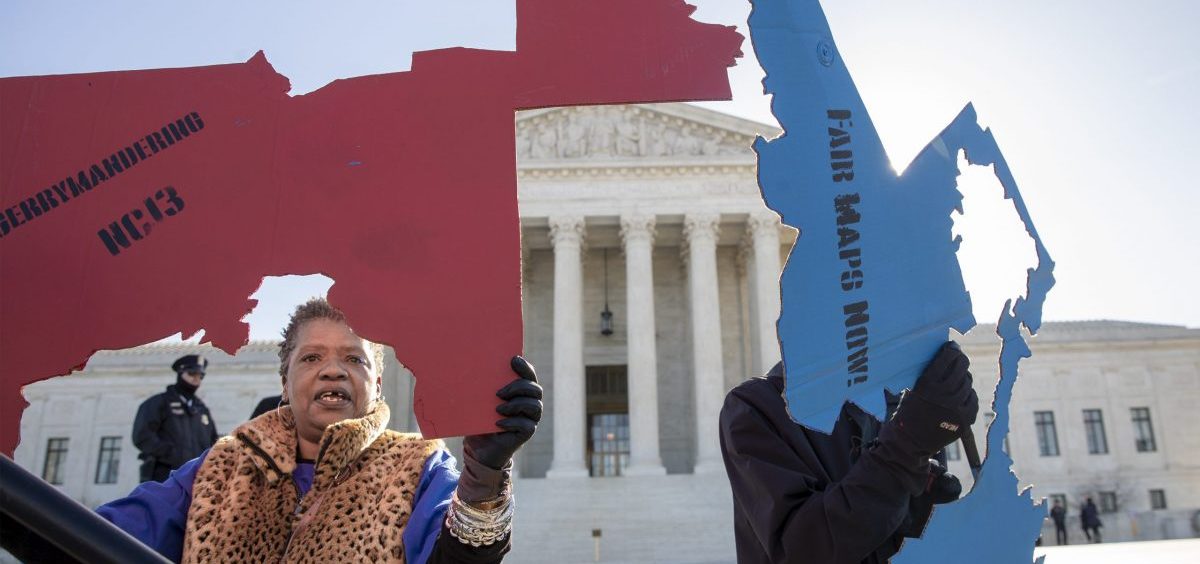 Demonstrators opposed to partisan gerrymandering hold up representations of congressional districts from North Carolina (left) and Maryland (right) outside the U.S. Supreme Court in Washington, D.C., in 2019.