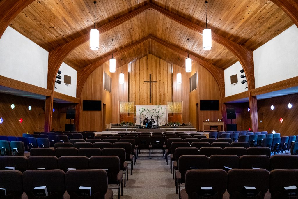 Inside the Church of the Nazarene with wooden walls and high arched ceilings.