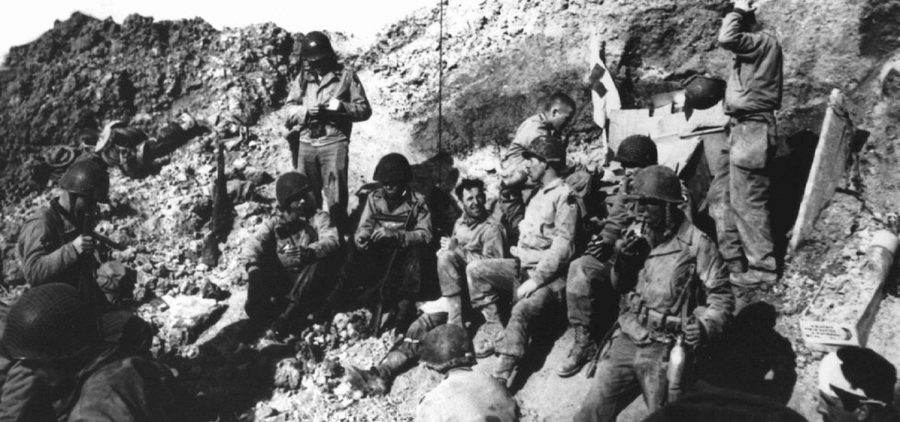 US soldiers sitting cliffside on D-Day at Pointe-Du-Hoc