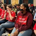 Protestors sit in the Ohio Senate with tape over their mouths