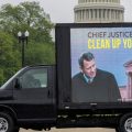A mobile billboard showing Supreme Court Chief Justice Roberts passes the U.S. Capitol