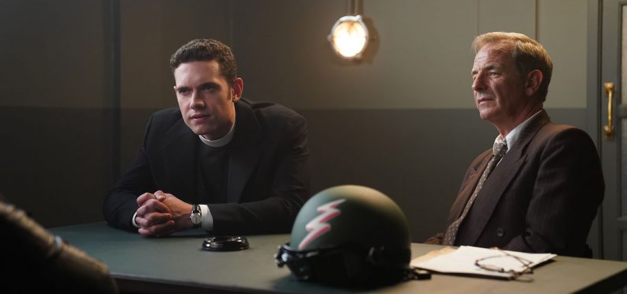Tom Brittney as Will Davenport and Robson Green as Geordie Keating sitting at interrogation table in Grantchester season 8