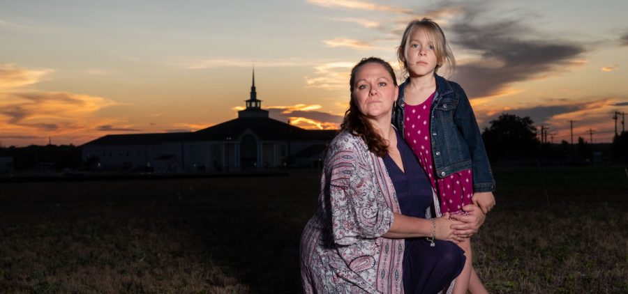 A mother and her transgender child outside of a church at sunset