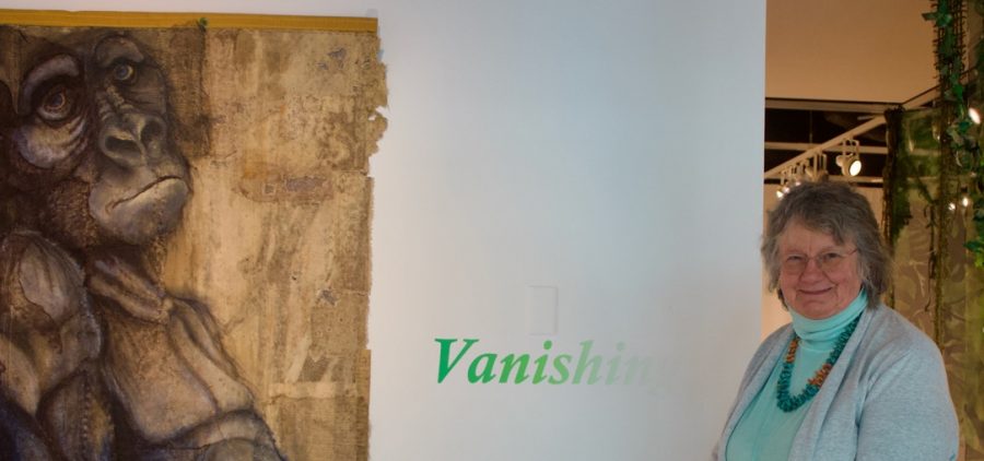 Holly Cole standing in front of her textile art exhibit titled Vanishing at the Trisolini Gallery