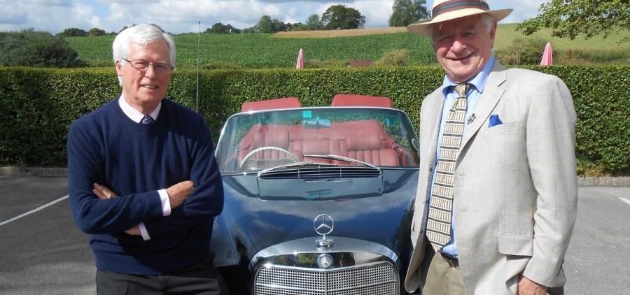 Johnny Ball and John Craven standing in front of Mercedes convertible