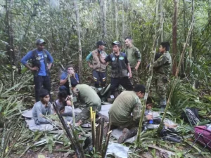 In this photo released by Colombia's Armed Forces Press Office, soldiers and Indigenous men tend to the four Indigenous brothers.