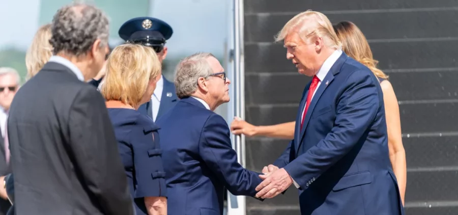 Former President Donald Trump shakes hands with Gov. Mike DeWine as he steps off Air Force One.