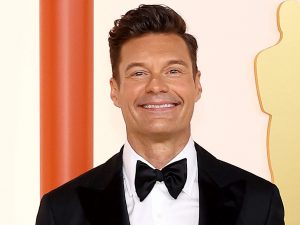 Ryan Seacrest poses for a picture on the red carpet at the Oscars