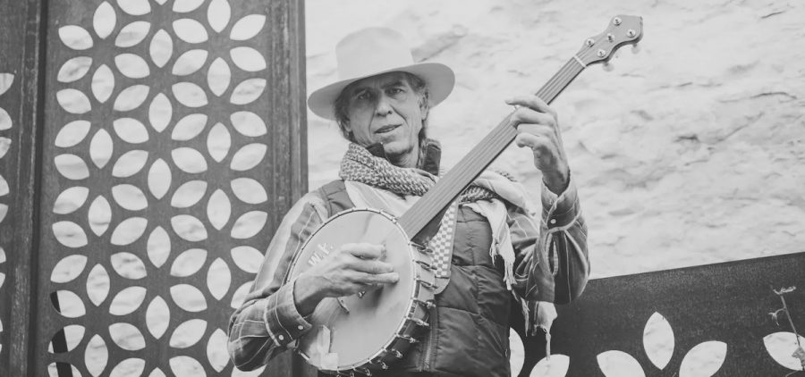 A promotional picture of Ralph White. He is wearing a hat and holding a banjo. The picture is in black and white.