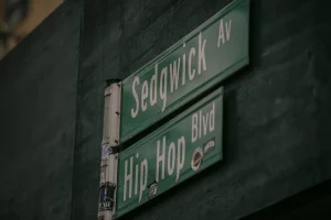 A picture of green street signs, one reading Sedgwick Avenue and the other Hip Hop Blvd.