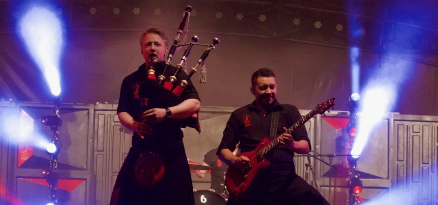 A electric guitar player and a bagpiper in action, contributing to the vibrant musical performance at the Lancaster Festival.