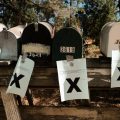 A row of mailboxes tagged with eviction notices sporting large black Xs.