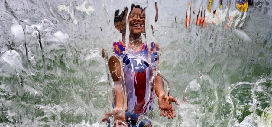a child plays in a waterfall feature at Yards Park in Washington, D.C., on June 26.