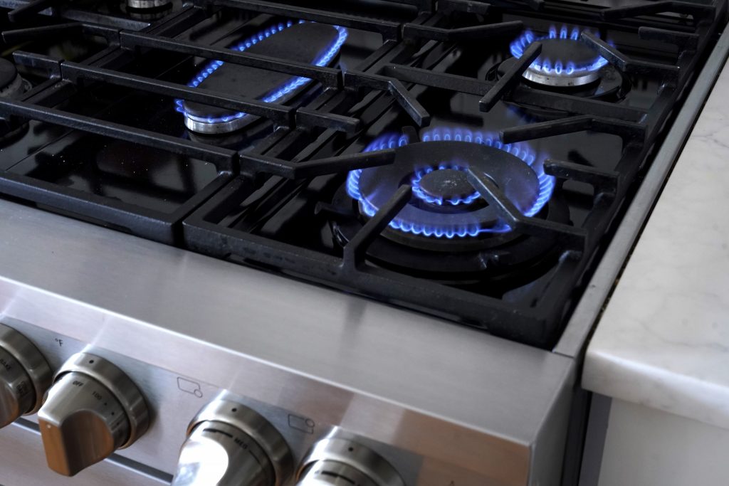 A gas stove with burners on.