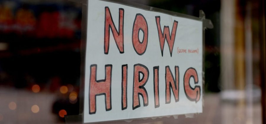 A 'Now Hiring' sign posted on the window of a business looking to hire workers on May 05, 2023 in Miami, Florida.
