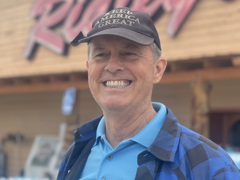 Michael Wetter from Stuart, Florida smiles outside of a store in a portrait