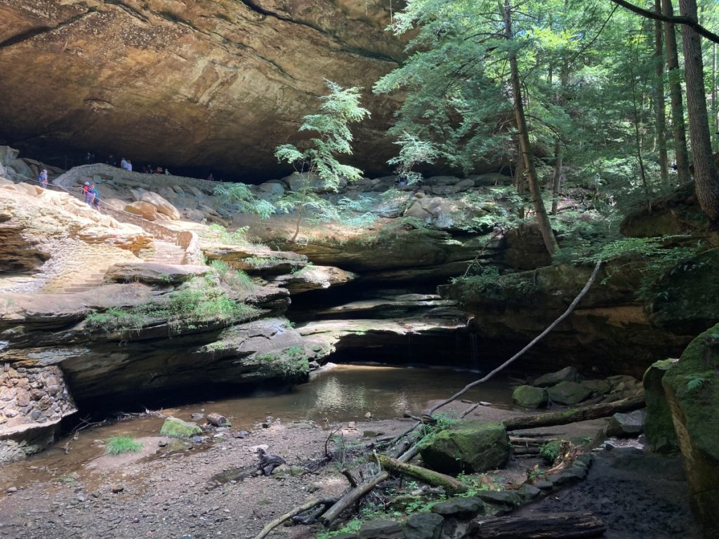 A view of Old Man's Cave, a large rock formation with a creek flowing through it.