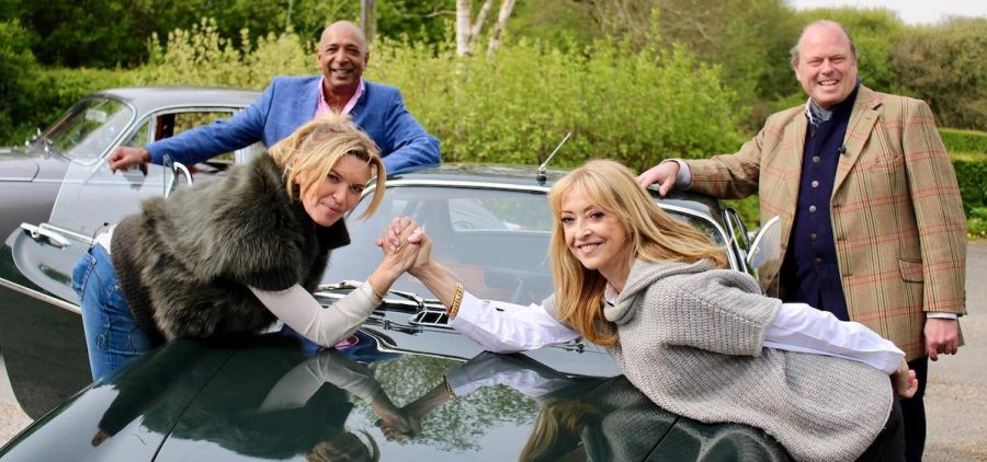 Former Holby City actors Tina Hobley and Sharon Maughan in arm wrestling pose on hood of car