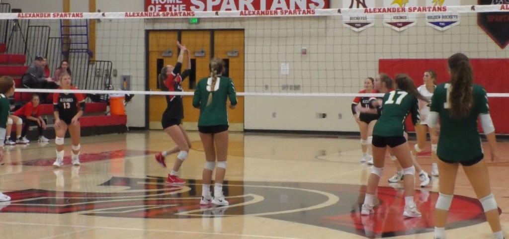 Alexander Spartan Lexi Grissett sets the volleyball to Macie Swart before a kill against the Athens Bulldogs