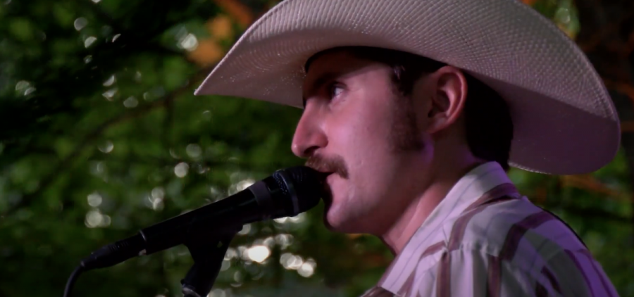 An image of Jesse Daniel performing during his 2023 Sycamore Session. He is wearing a white cowboy hat.