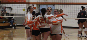High School Girls' Volleyball: Nelsonville-York Buckeyes celebrate in a huddle after a point victory. Photo Credit: [Jamey Spears | WOUB]