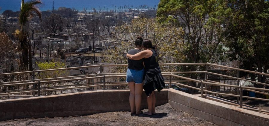 Two women embrace and cry as they look out over a burned area in Lahaina, Hawaii