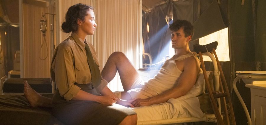 Lois Bennett (JULIA BROWN) and Harry Chase (JONAH HAUER-KING) Woman sitting at end of bed of soldier, ray of sun coming through window, crutches propped against bed. Credit: Mammoth Screen, Steffan Hill