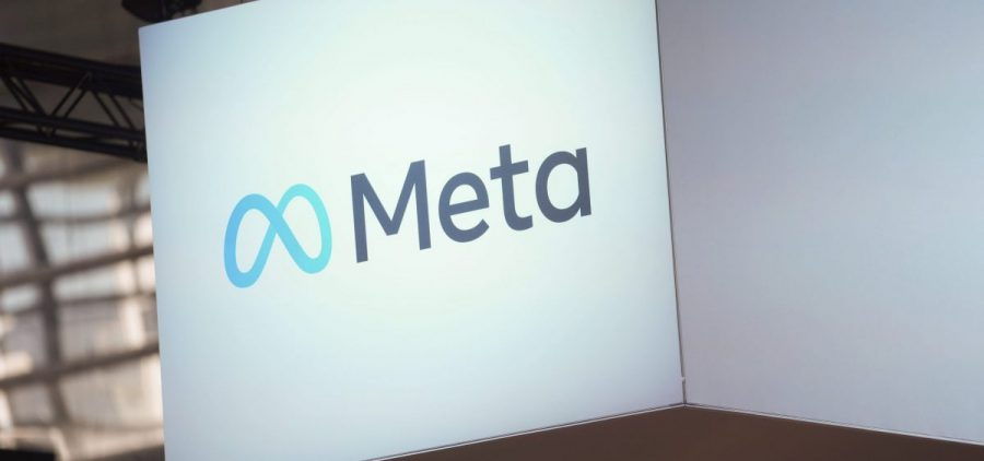 The Meta logo is on a cube display hanging from a ceiling.