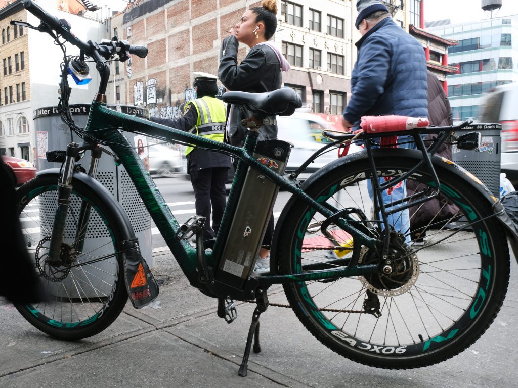 An electric bicycle stands parked in the streets of Manhattan.