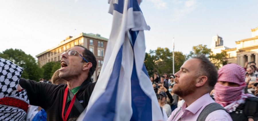 A man holds up an Israeli flag as Columbia University students participate in a rally in support of Palestine at the university on October 12 in New York City.