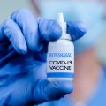 Close up Hands of Doctor or nurse holding Intranasal vaccine spray bottle for COVID-19