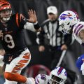 Cincinnati Bengals quarterback Joe Burrow (9) runs with the ball as Buffalo Bills defensive end Leonard Floyd (56) and safety Taylor Rapp try to stop him during the second half of an NFL football gam