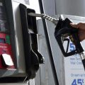 A customer replaces the pump dispenser at a Chevron gas station in Columbus, Miss.