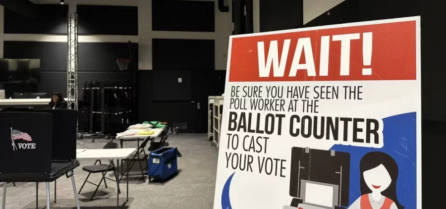 A sign at a polling place reminds people to see a poll worker with their ballot to make sure they cast their vote.