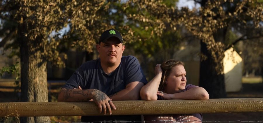 Army veteran Ray Queen stands with his wife, Rebecca Queen, outside their home in Bartlesville, Okla. An NPR investigation has found that thousands of U.S. military service members and veterans, including the Queen family, are at risk of losing their homes through no fault of their own.