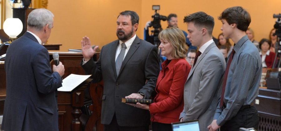 Brian Chavez is sworn into office with his wife and two children standing by his side.