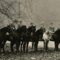 Twelve midwives on horseback in country wooded area