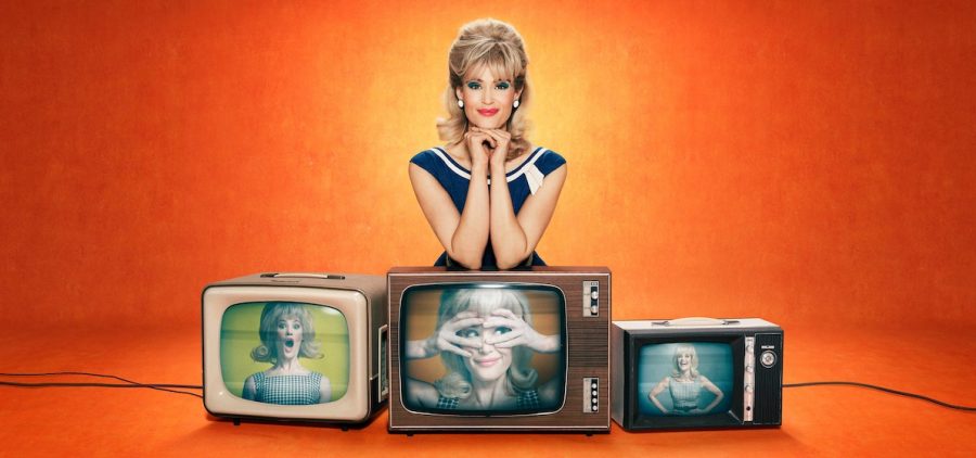 women with hands under chin, elbows leaning on TV centered under her. Two TV's on either side