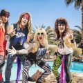 A promotional image of the band Steel Panther. All four members are outside next to a pool wearing '80s style rockstar outfits.