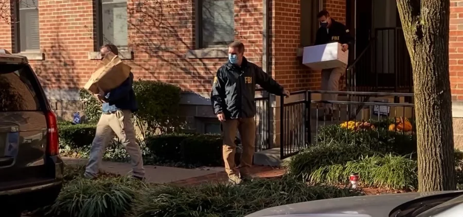 FBI Agents carry boxes out of a home