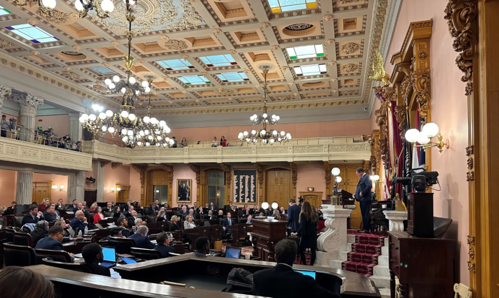 Representatives sit in the chamber of the Ohio House of Representatives. The speaker is at the podium.