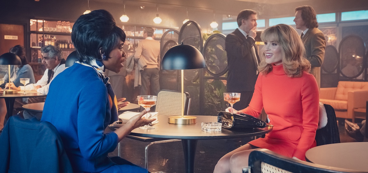 Barbara (Gemma Arterton) and Diane (Clare-Hope Ashitey) discuss their latest career moves sitting at a small round table in a 1950's bar. Credit© Potboiler Productions; © Sky UK Limited